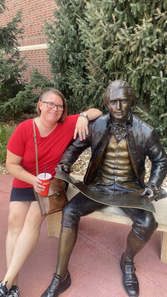 Kimberly sitting next to a metal statue on a visit to St. Louis to visit some friends